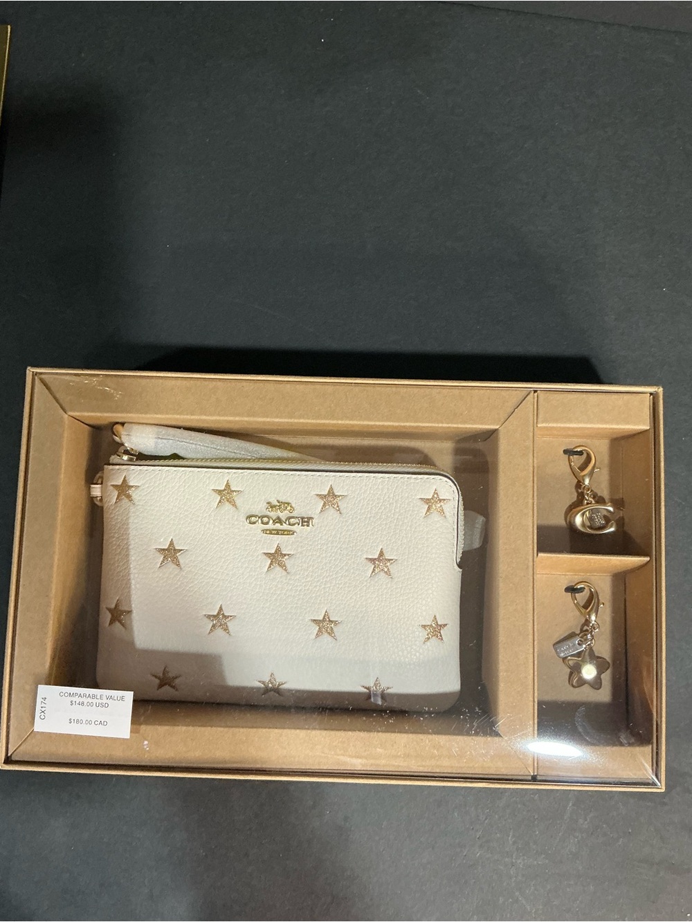 The Coach Boxed Corner Zip Wristlet With Star Print And Charms